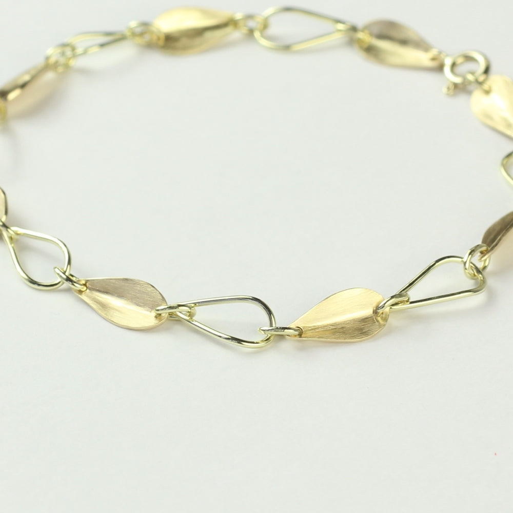 Close-up van schakels van 14 karaat gouden armband Leaves, met afwisselend open en dichte blaadjes.