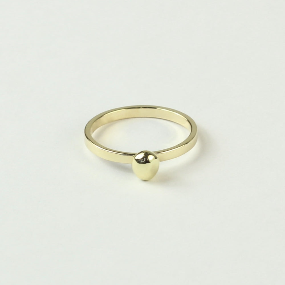 Schuin vooraanzicht minimalistische gouden ring met gouden steentje uit collectie Essentials. Op een witte ondergrond