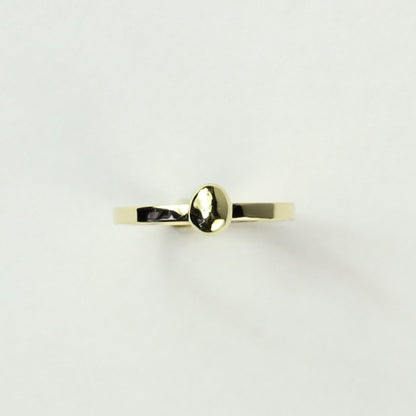 Bovenaanzicht minimalistische gouden ring met gouden steentje uit collectie Essentials. Op een witte ondergrond