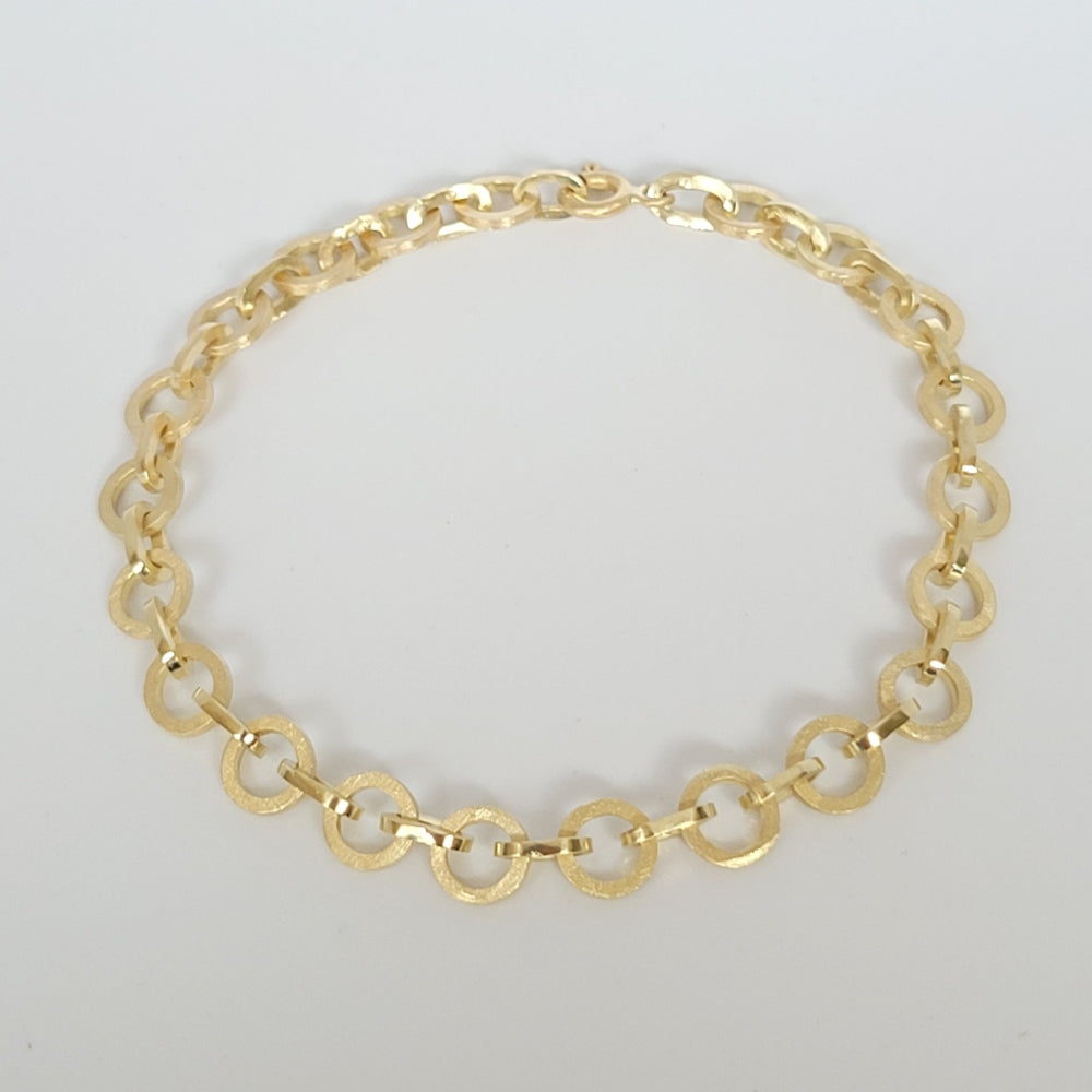 Unieke 14 karaat gouden schakelarmband met matte ronde schakels afgewisseld met hoogglans ovale schakels. Slechts een van gemaakt. Liggend op een witte achtergrond.